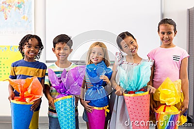 Smiling multi ethnic children holding artwork Stock Photo