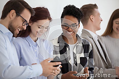 Smiling multi-ethnic people holding phones having fun with mobile devices Stock Photo