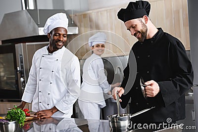 smiling multicultural chefs cooking together Stock Photo