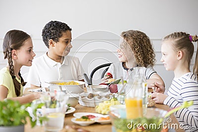 Smiling multicultural group of children eating food Stock Photo