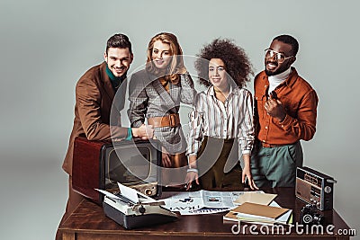 smiling multicultural retro styled journalists looking at camera in office Stock Photo