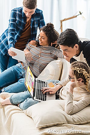 smiling multicultural teenagers looking at laptop Editorial Stock Photo