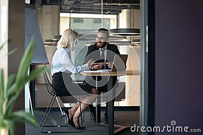 Smiling multiethnic colleagues discuss ideas in office together Stock Photo