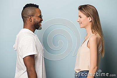 Smiling multiethnic man and woman in profile look in eyes Stock Photo