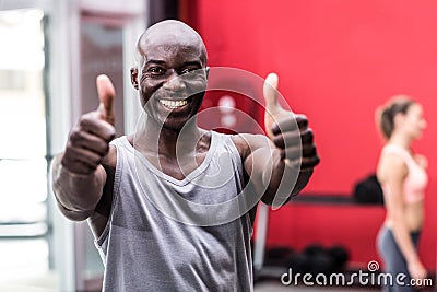 Smiling muscular man gesturing thumbs up Stock Photo