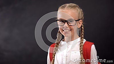 Smiling nerd girl looking at camera, happy to come back to school, education Stock Photo