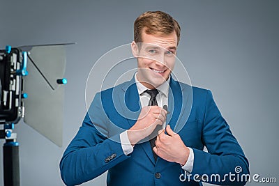 Smiling newsman adjusting the microphone Stock Photo