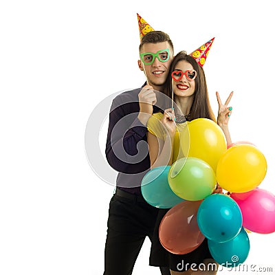 Smiling nice guy and girl with cones on their heads held near persons paper dummies and balloons Stock Photo