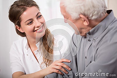 Smiling nurse assisting senior man Stock Photo