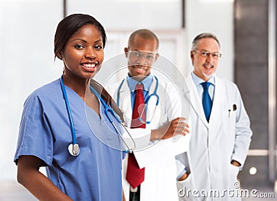 Smiling nurse in front of her medical team Stock Photo