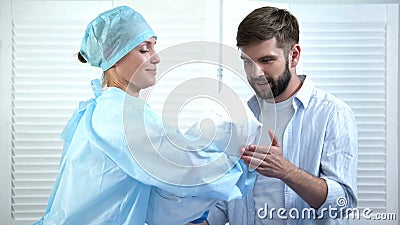 Smiling nurse giving young happy father newborn child, miracle of birth, care Stock Photo