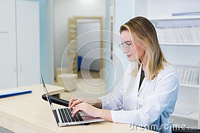 Smiling nurse with laptop scheduling appointment for male patient at reception Stock Photo