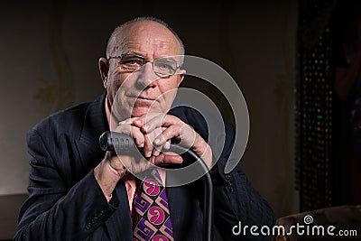 Smiling Old Bald Businessman Holding his Cane Stock Photo