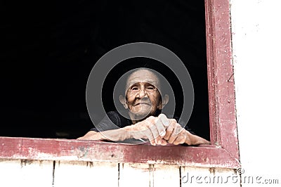 Smiling old woman in window Editorial Stock Photo