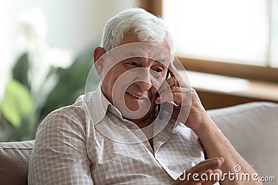 Smiling older man talking on phone, chatting with relatives Stock Photo