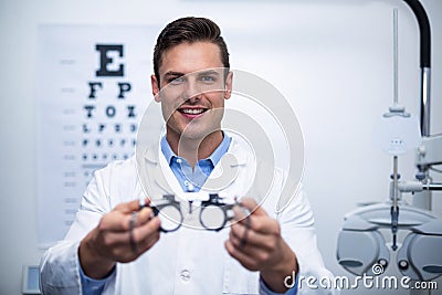 Smiling optometrist holding messbrille Stock Photo