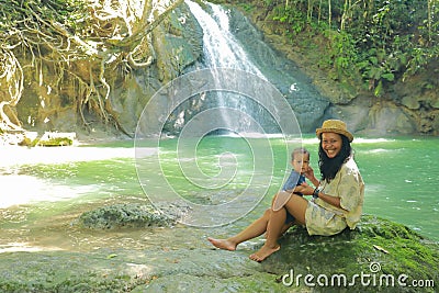 Mom and son on Wafsarak Waterfall on Biak Island Stock Photo