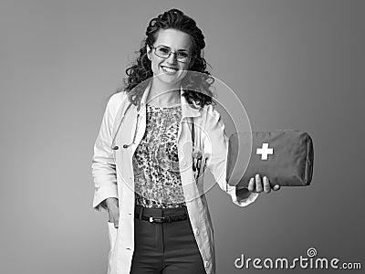 Smiling pediatrician woman giving first-aid kit on Stock Photo