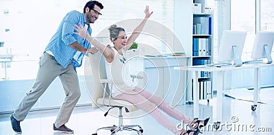 Smiling photo editors having fun with on a swivel chair Stock Photo