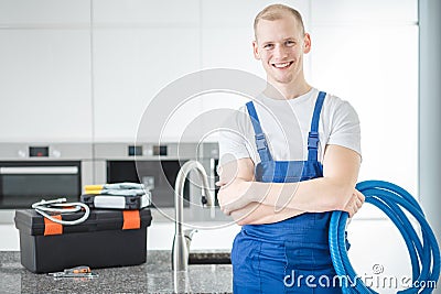 Smiling plumber with blue pipes Stock Photo