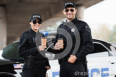 Smiling police officers in sunglasses holding Stock Photo