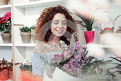 Smiling positive red-haired woman lovely looking on colorful bouquet Stock Photo