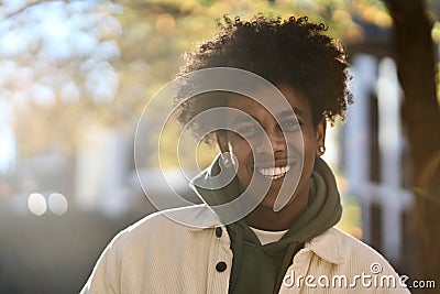 Happy young gen z African American teen standing at sunny city park. Portrait Stock Photo