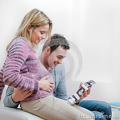 Smiling pregnant couple with ultrasound scan Stock Photo