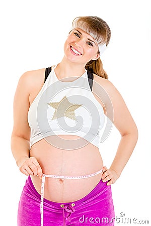 Smiling pregnant woman measuring her belly Stock Photo