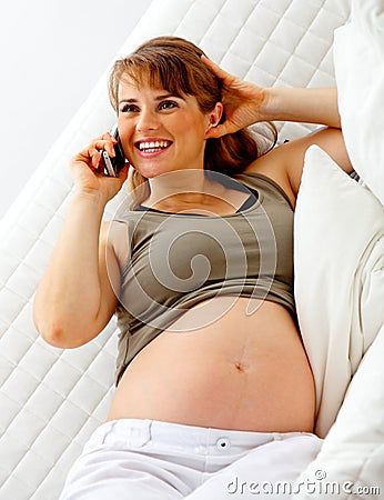 Smiling pregnant woman talking mobile phone Stock Photo