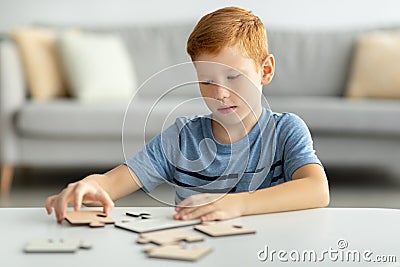 Preteen boy playing with wooden puzzles at home Stock Photo