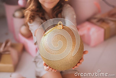 Smiling pretty girl holding huge golden holiday ball in hands Stock Photo
