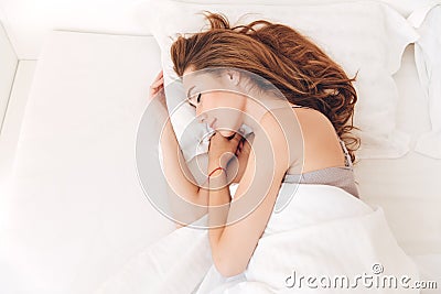 Smiling pretty lady sleep in bed indoors. Eyes closed. Stock Photo