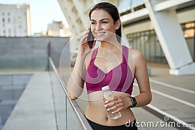 Happy young athletic using mobile phone outdoor Stock Photo