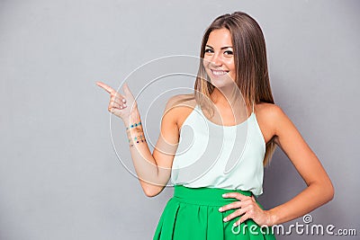 Smiling pretty woman pointing finger away Stock Photo