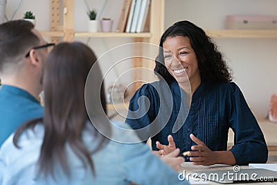 Smiling professional african american financial advisor talking to clients. Stock Photo