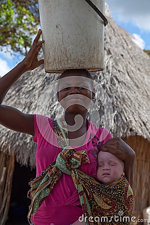 Smiling proud young African woman with sleeping albino child in a capulana on hip. Editorial Stock Photo