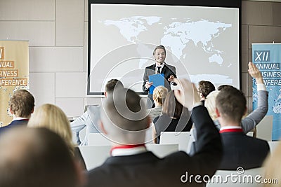 Smiling public speaker asking questions to audience during seminar Stock Photo