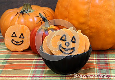 Smiling pumpkin shaped sugar cookies in a black bowl Stock Photo