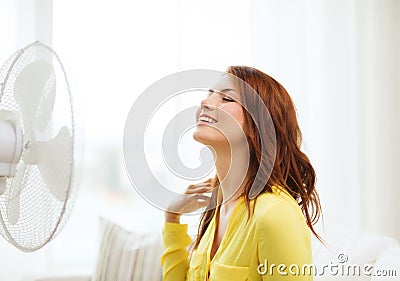 Smiling redhead teenage girl with big fan at home Stock Photo