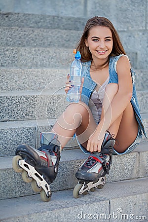 Smiling roller girl sitting on the stairs Stock Photo