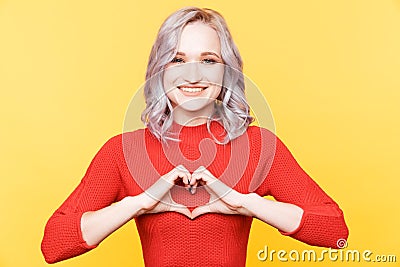 Smiling romantic person showing heart getsure isolated. Stock Photo