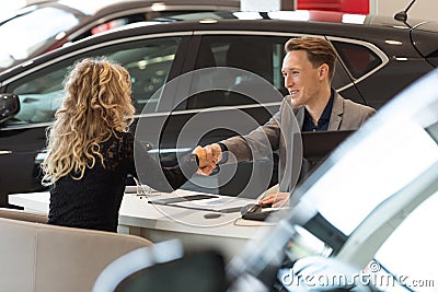 Smiling salesman doing handshake with female customer Stock Photo