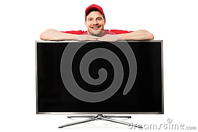 smiling salesman in red uniform over big blank tv screen Stock Photo