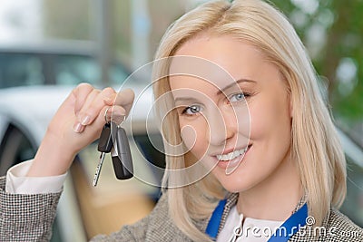 Smiling salesperson presenting a car key Stock Photo