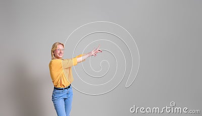 Smiling saleswoman with arms raised pointing at new product and marketing on white background Stock Photo