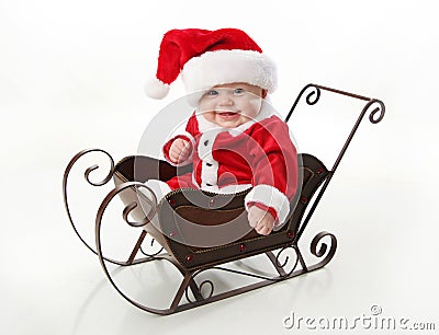 Smiling santa baby sitting in a sleigh Stock Photo