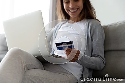 Smiling satisfied online store female customer using card for shopping. Stock Photo