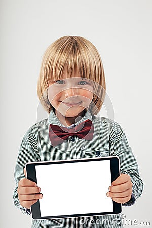 Smiling School boy in shirt with red bow tie, holding tablet computer in white background Stock Photo