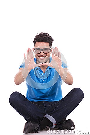 Smiling seated casual man making a hands frame Stock Photo